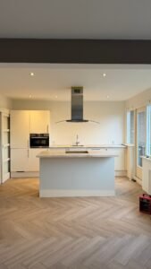 Gewrapte keuken in Hellevoetsluis met strakke moderne fronten met een licht eiland