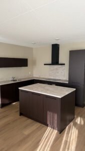 Gewrapte keuken in Bergen op Zoom met keukenkasten in walnoot met een beige marmerlook werkblad en spatwand