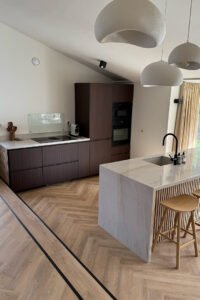 Gewrapte keuken in Arkel met keukenfronten in een warme donkere houtlook, met het marmeren eiland behouden