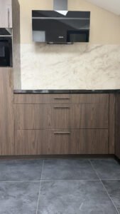 Detailopname van de gewrapte keuken in Sint-Michielsgestel, warme houtlook met marmerlook achterwand