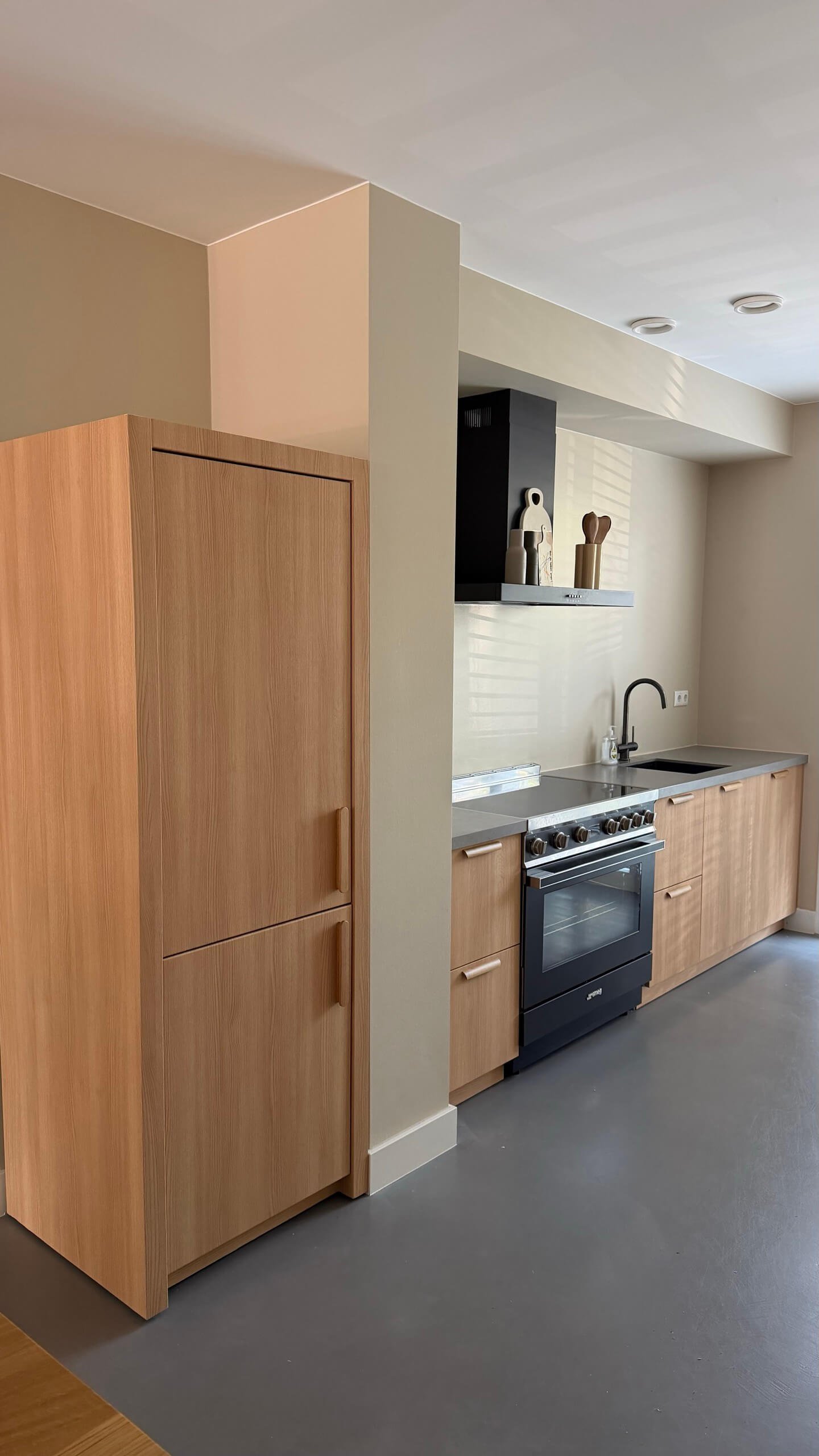 Dezelfde keuken in Breda na het wrappen, met fronten in een lichte houtlook
