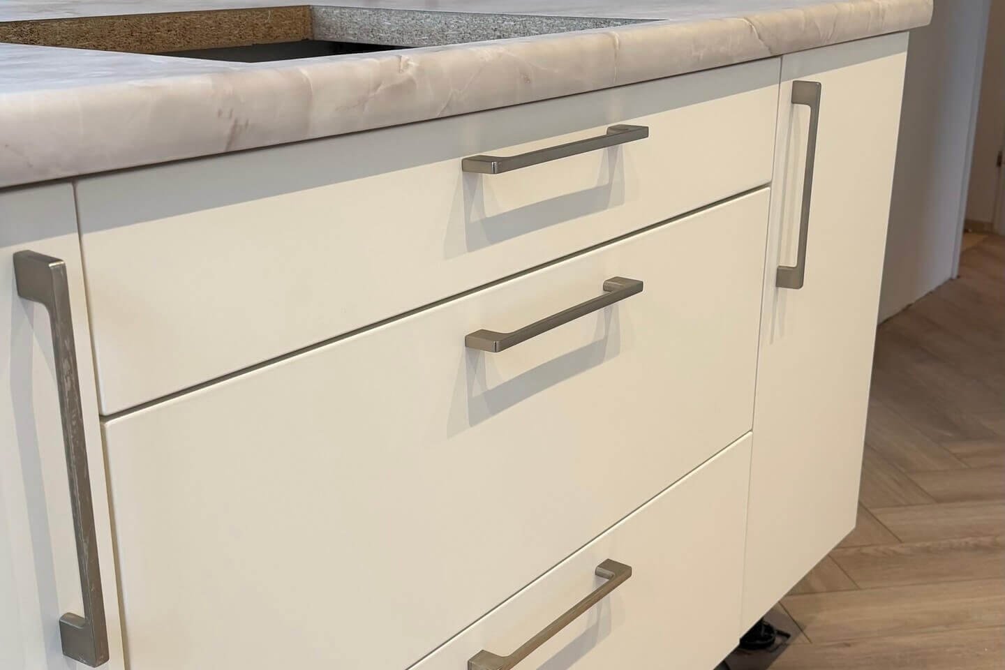 Gewrapte ladefronten in de cremetint Cream met een werkblad in marmerlook, met de folie strak om de randen