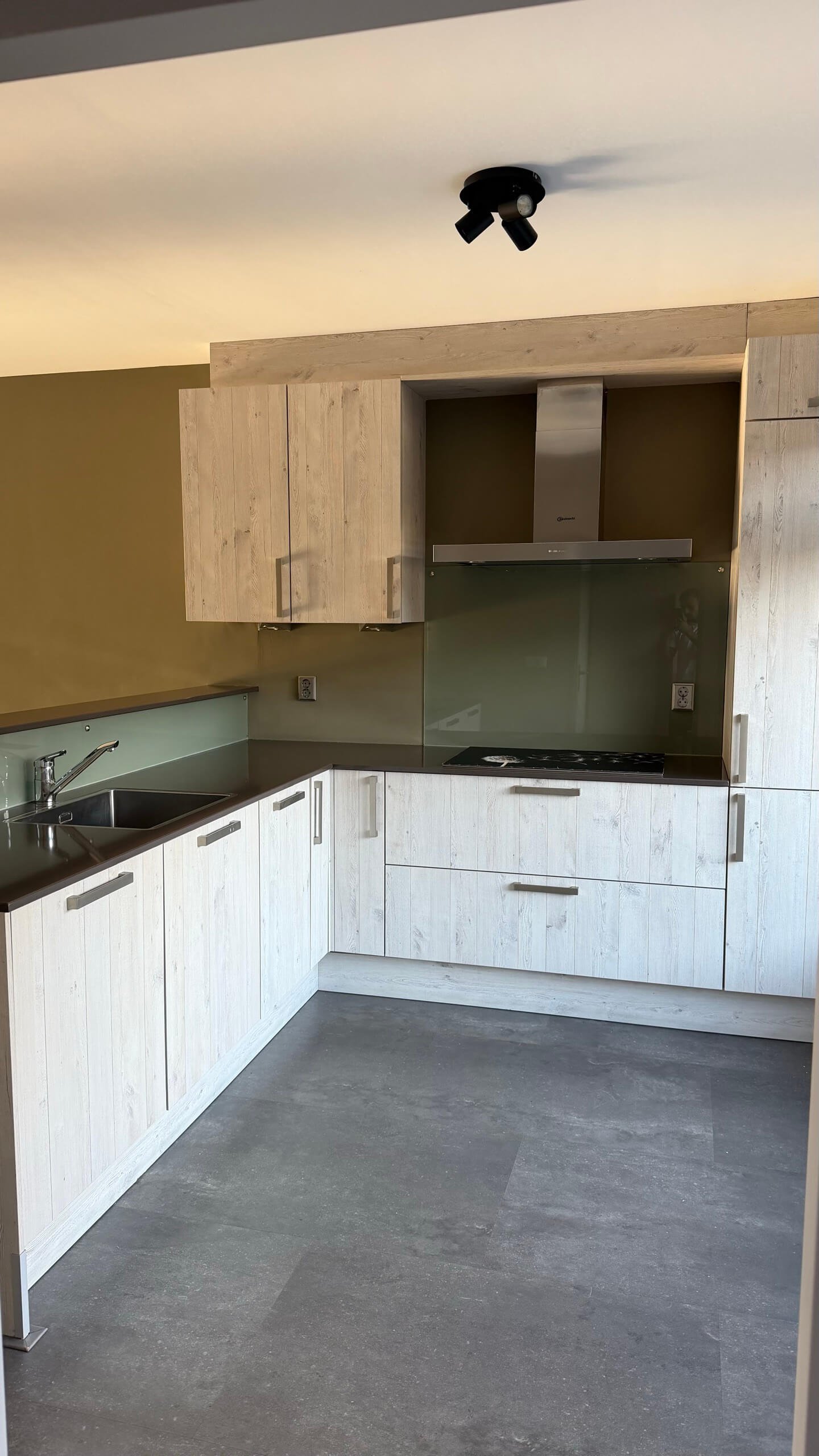 Keuken in Heenvliet voor het wrappen, lichte houtlook met een groene glazen achterwand