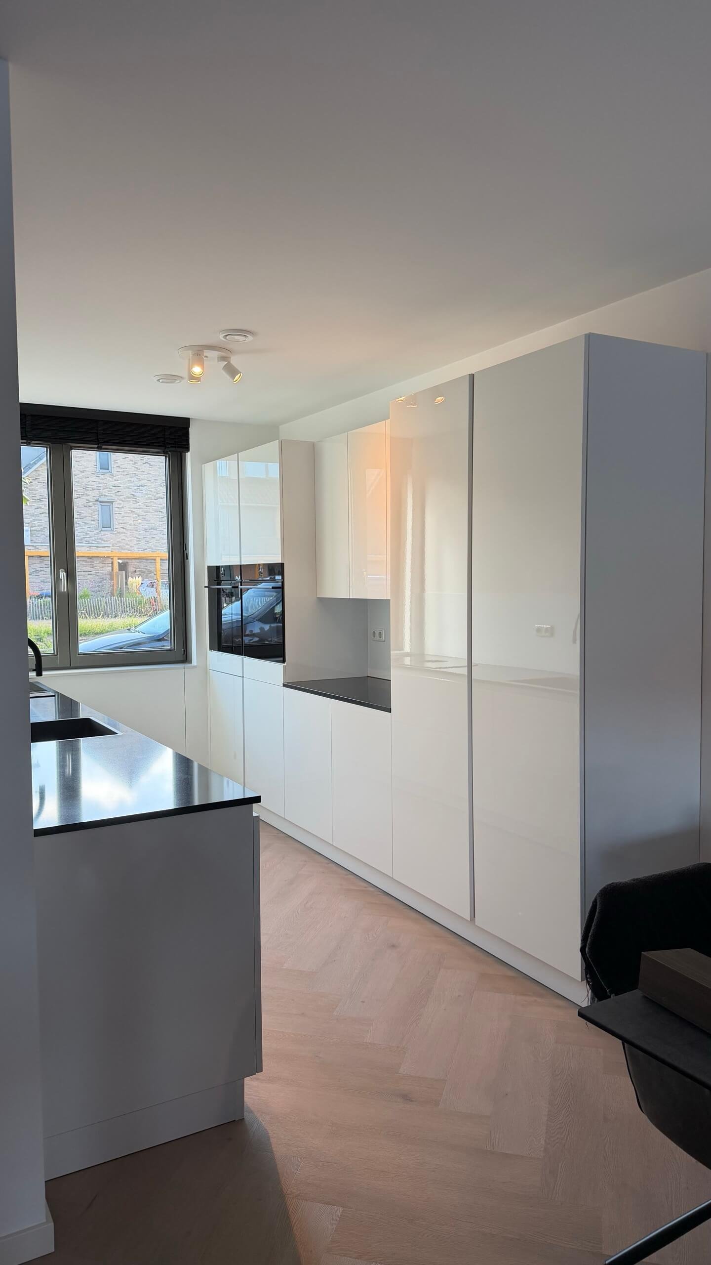 Keuken in Hoef en Haag voor het wrappen, hoogglans wit met een donker werkblad