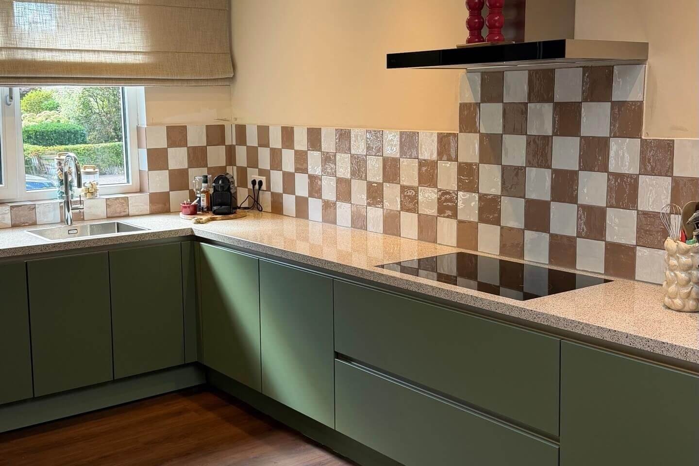 Gewrapte keuken in de groene tint Pond met een lichte werkbladrand en een geblokte tegelachterwand