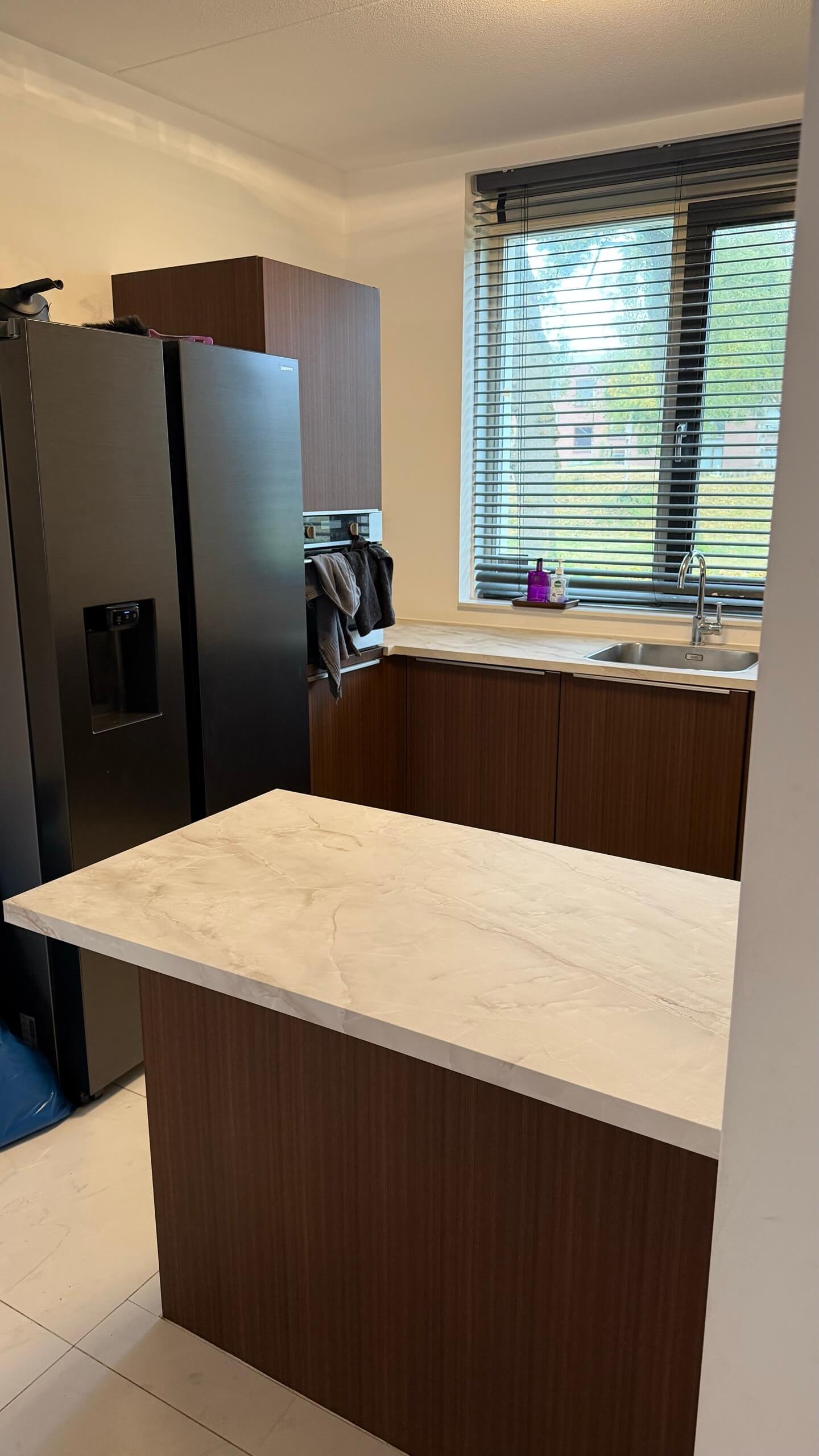 Het schiereiland van de gewrapte keuken in Rotterdam met een werkblad in marmerlook