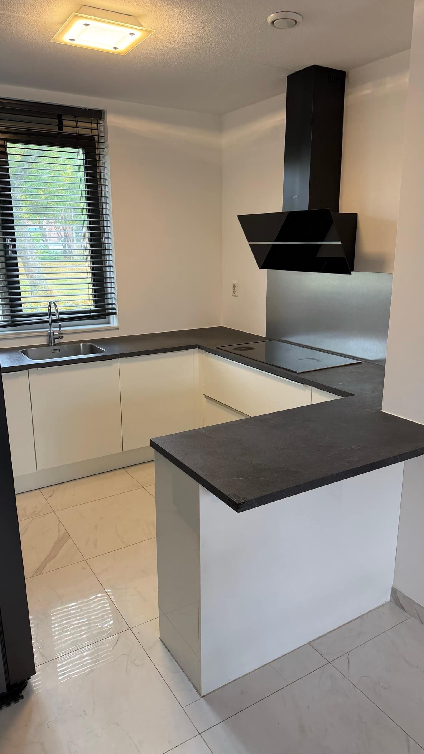 Keuken in Rotterdam voor het wrappen, met witte fronten en een donkergrijs werkblad