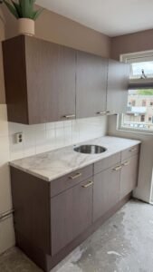 Gewrapte keuken in Maassluis met keukenkasten in de houtlook Pavo Dark met een werkblad in Bright Onyx marmerlook