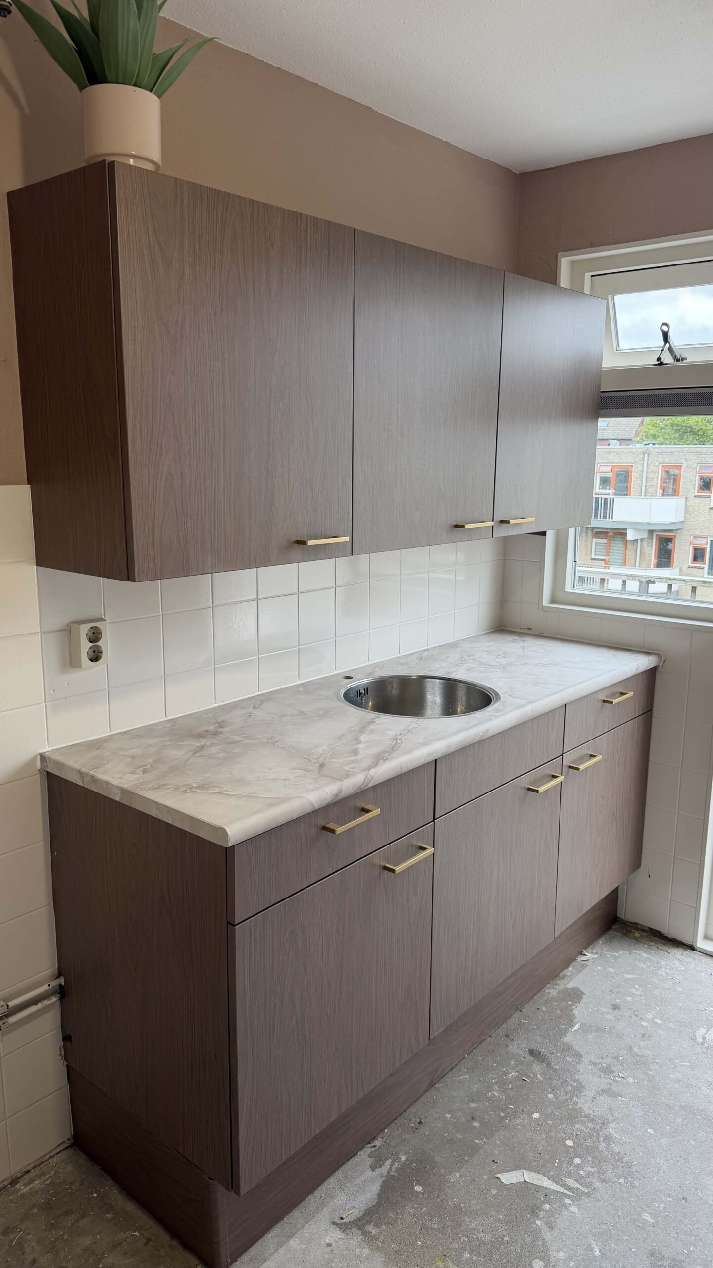 Gewrapte keuken in Maassluis met keukenkasten in de houtlook Pavo Dark met een werkblad in Bright Onyx marmerlook