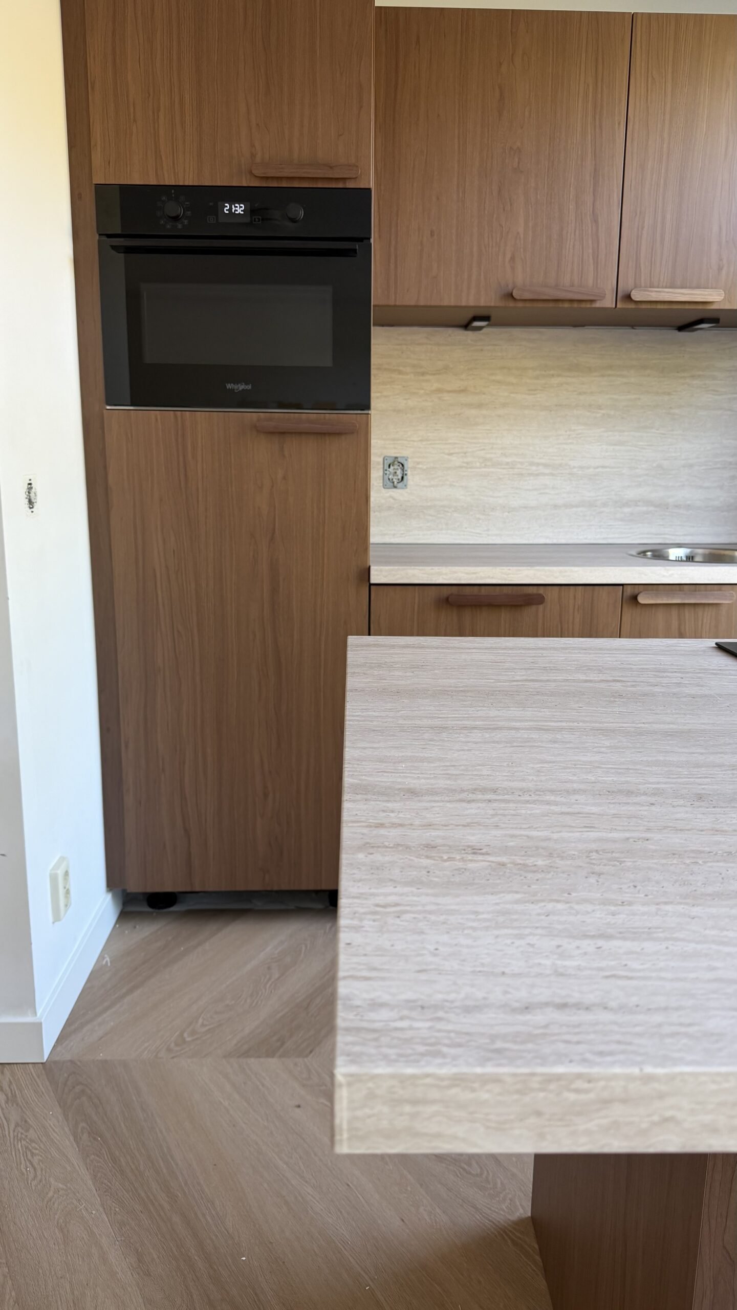 De afwerking van de gewrapte keukenfronten in Purmerend, warme houtlook