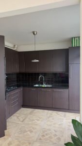 Gewrapte keuken in Wateringen met keukenkastjes in de donkerbruine houtlook Navis