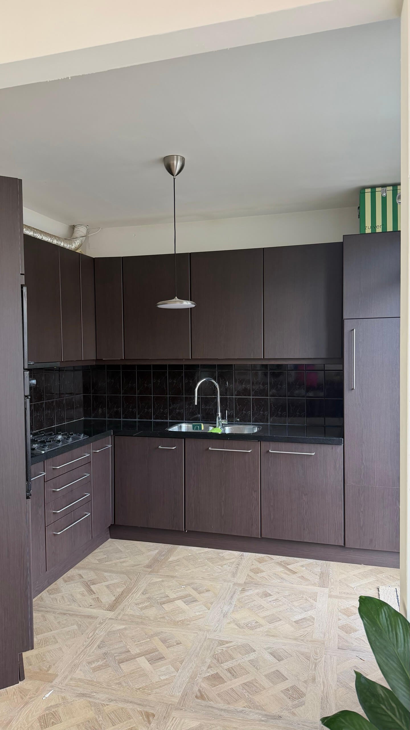Gewrapte keuken in Wateringen met keukenkastjes in de donkerbruine houtlook Navis