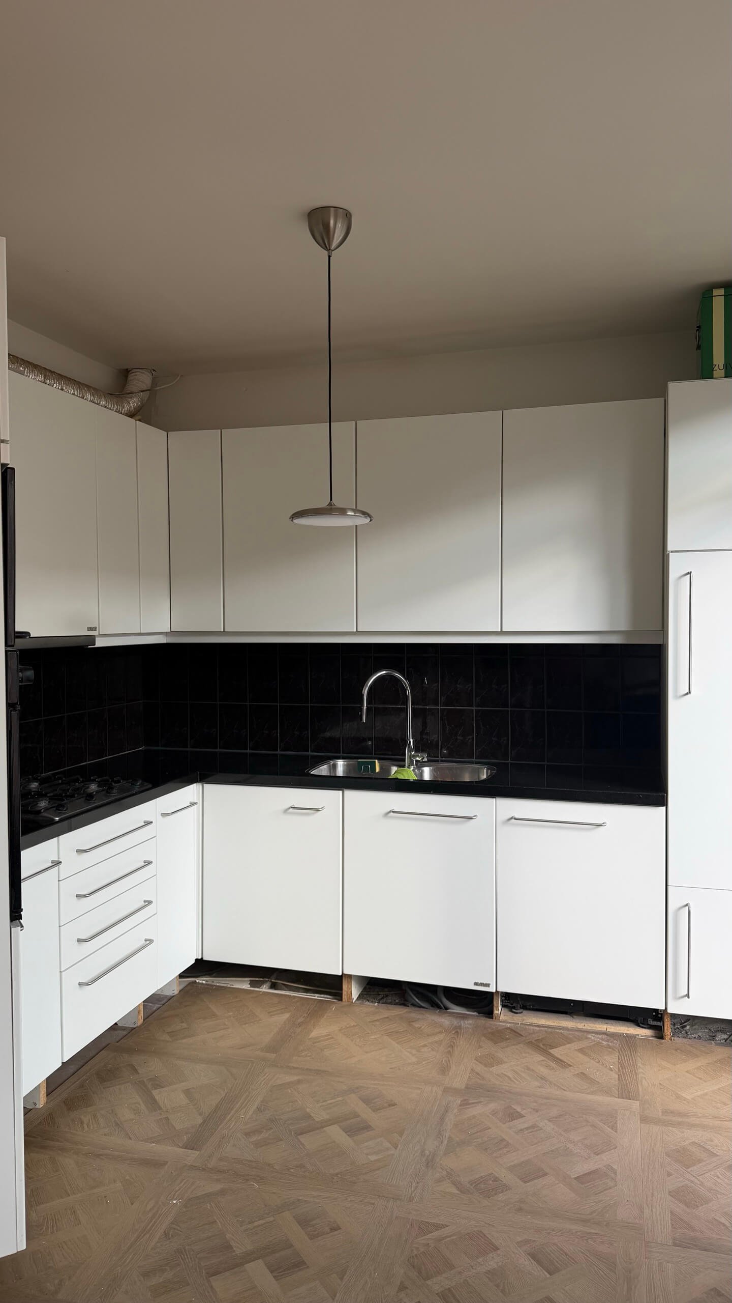 Keuken in Wateringen voor het wrappen, met witte hoogglans fronten en een donker werkblad
